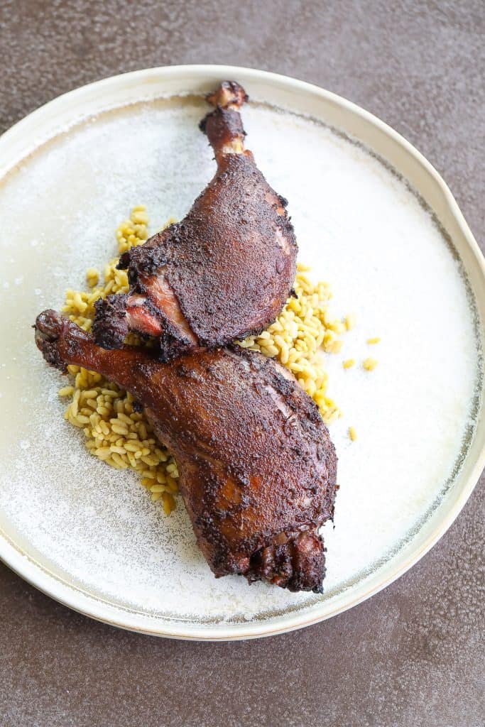 smoked duck on a  tan plate with rice