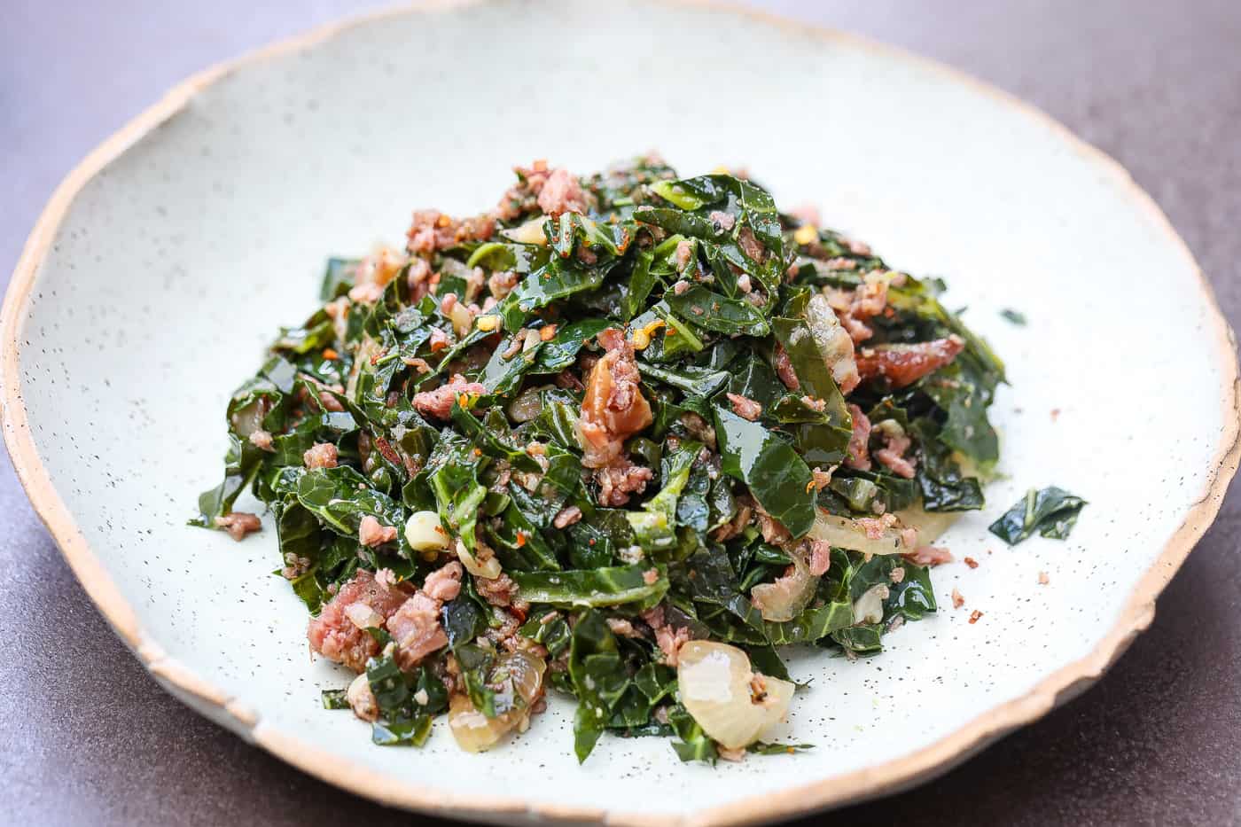 brazilian collard greens and turkey pices on a green plate