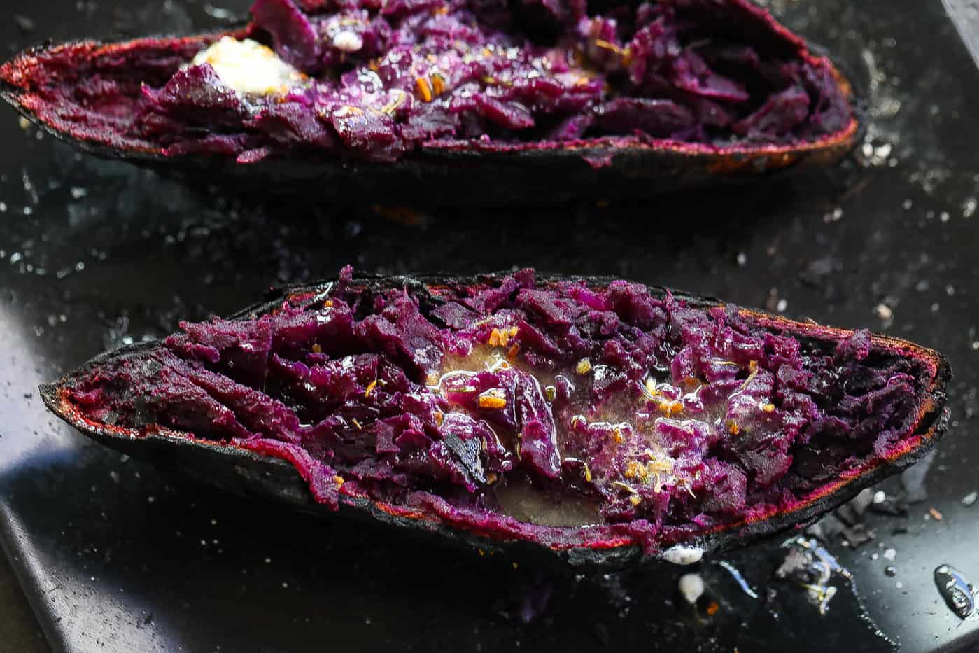 purple sweet potato halves on a black plate