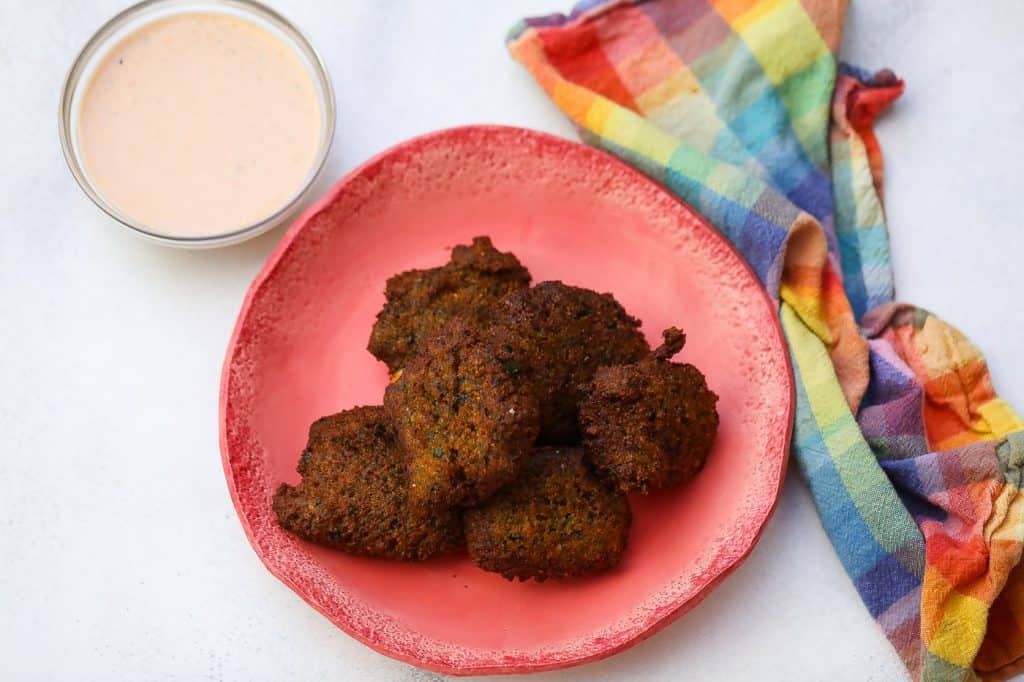 blackeyed pea falafel on a plate with tahini sauce