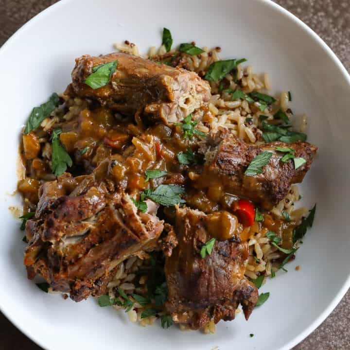 smothered turkey necks on top of a bowl of rice