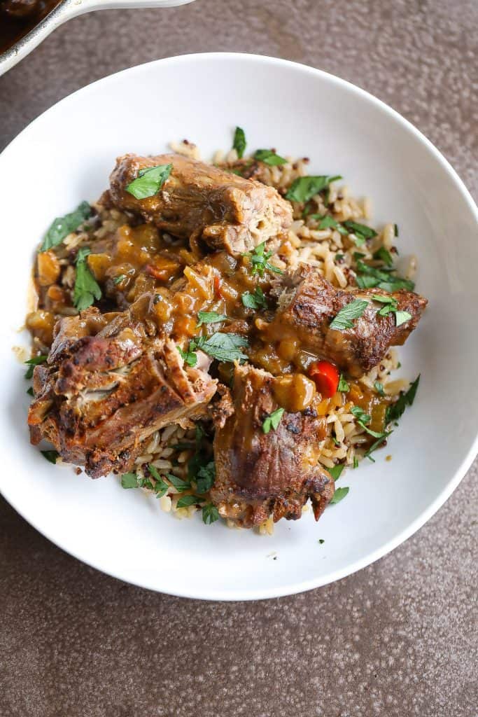 smothered turkey necks on top of a bowl of rice