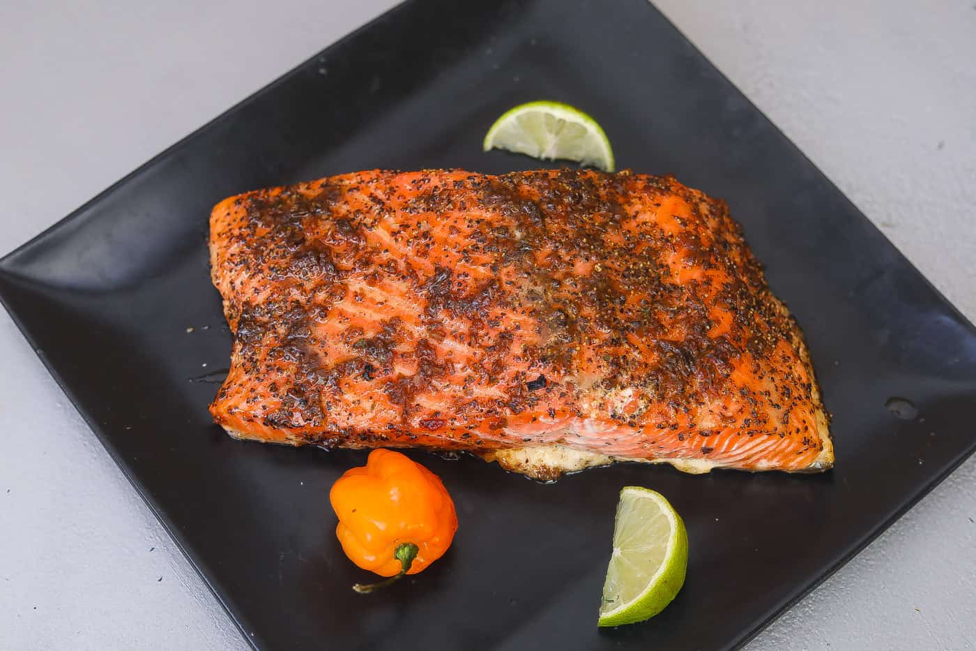 glazed jerk salmon on a black plate