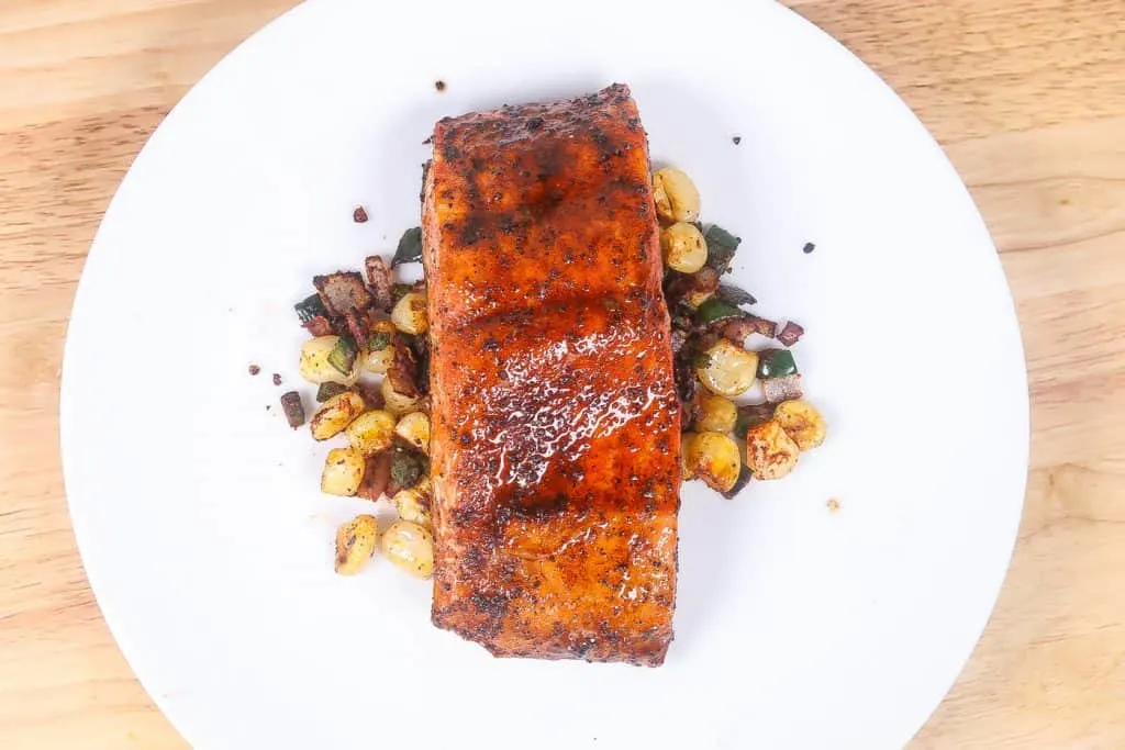broiled salmon with corn on a white plate