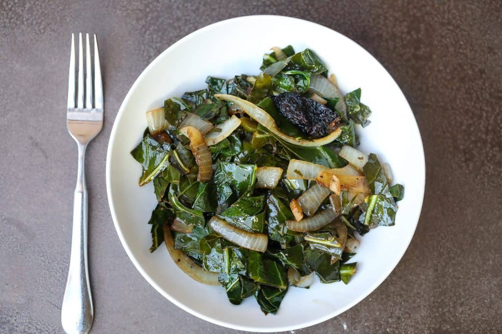collard greens and onions in white bowl