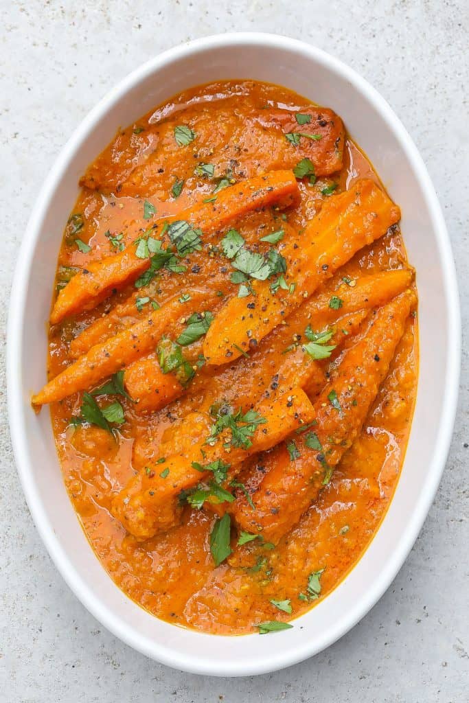 carrot curry in white oval bowl topped with cilantro