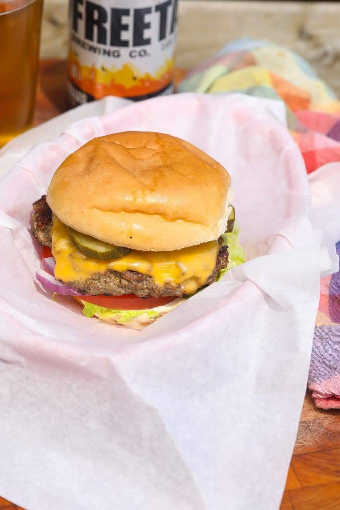 smashburger with cheese on cutting board