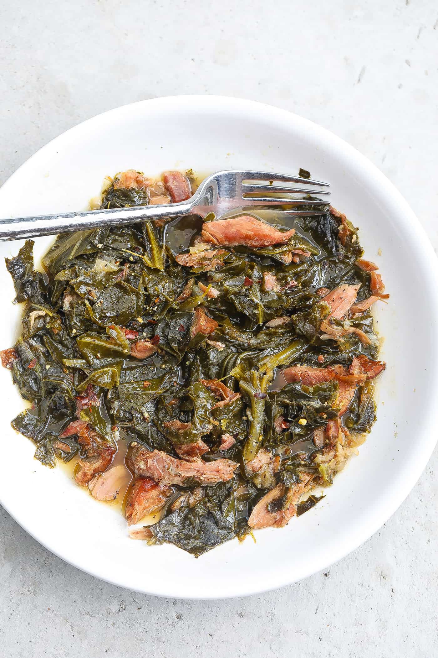 collard greens and turkey in white bowl