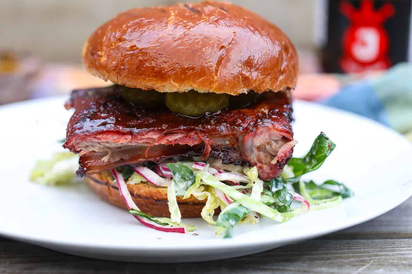 smoked rib sandwich on white plate