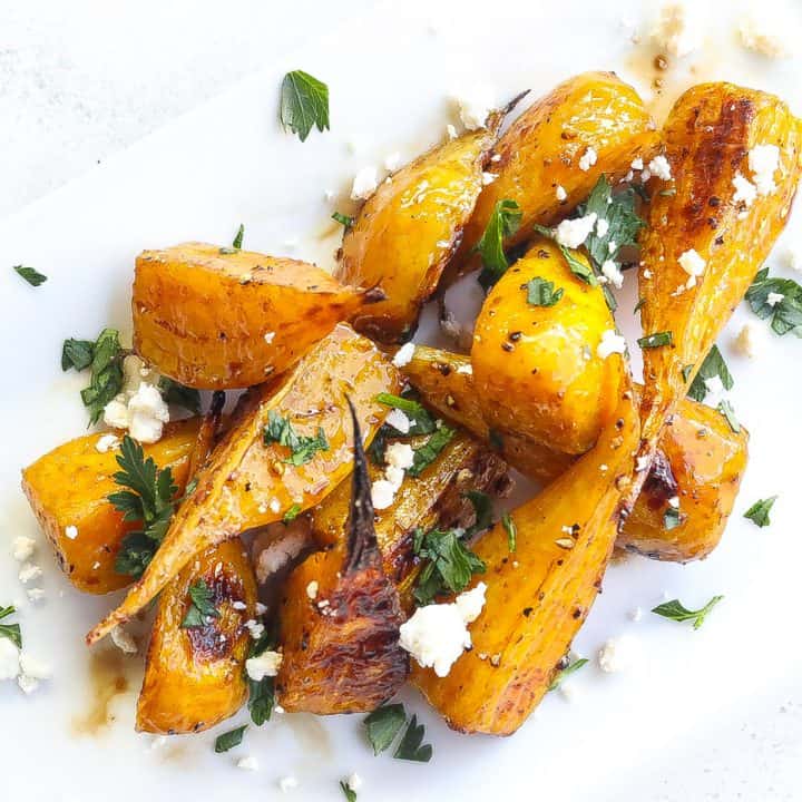 golden beets on a white plate topped with feta and parsley
