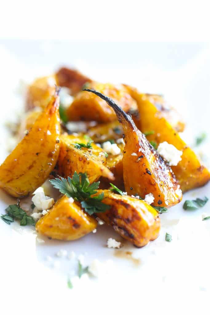 golden beets on a white plate topped with feta and parsley