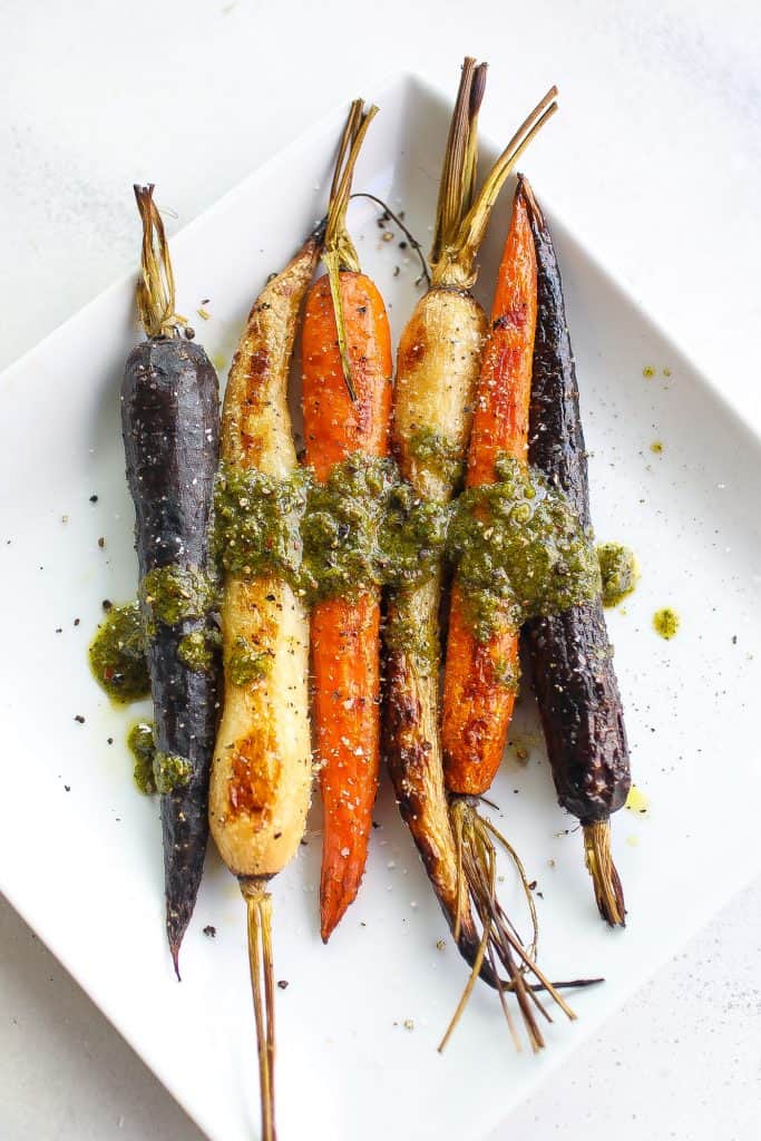 simple smoked carrots on white plate topped with green salsa
