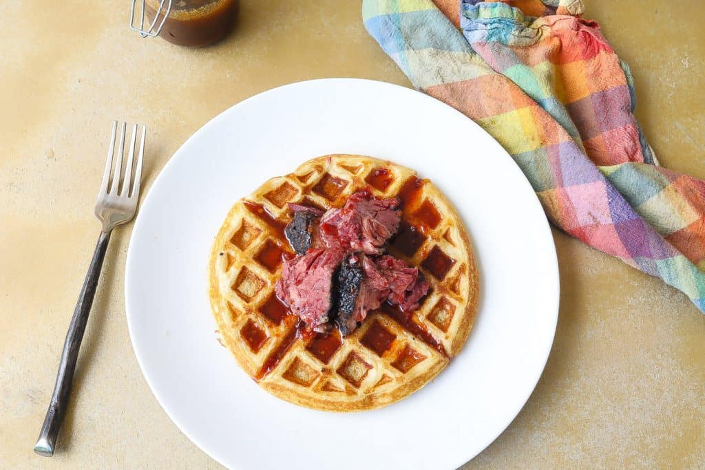 buttermilk waffle topped with smoked brisket and spicy syrup