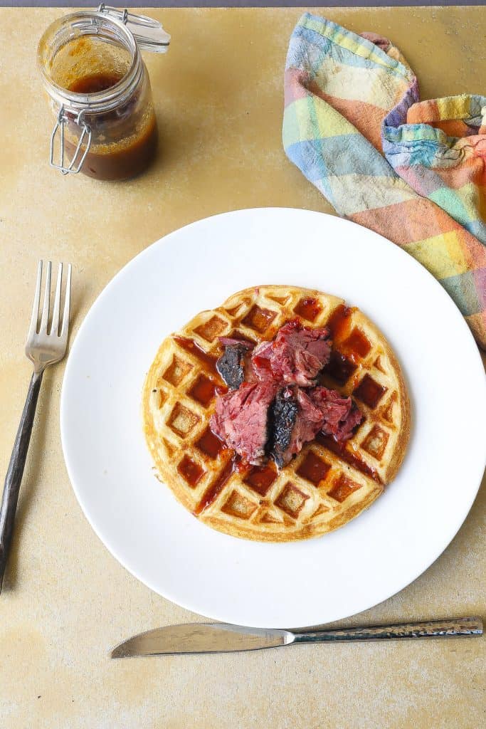 buttermilk waffle topped with smoked brisket and spicy syrup