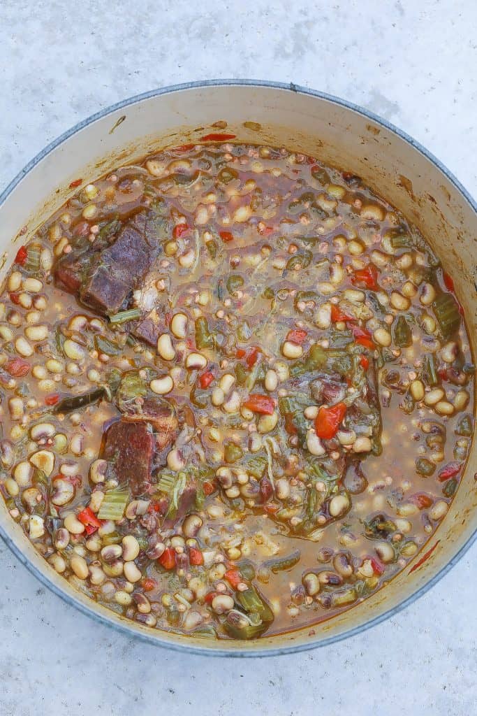 peas in a pot with peppers, okra, and neck bones
