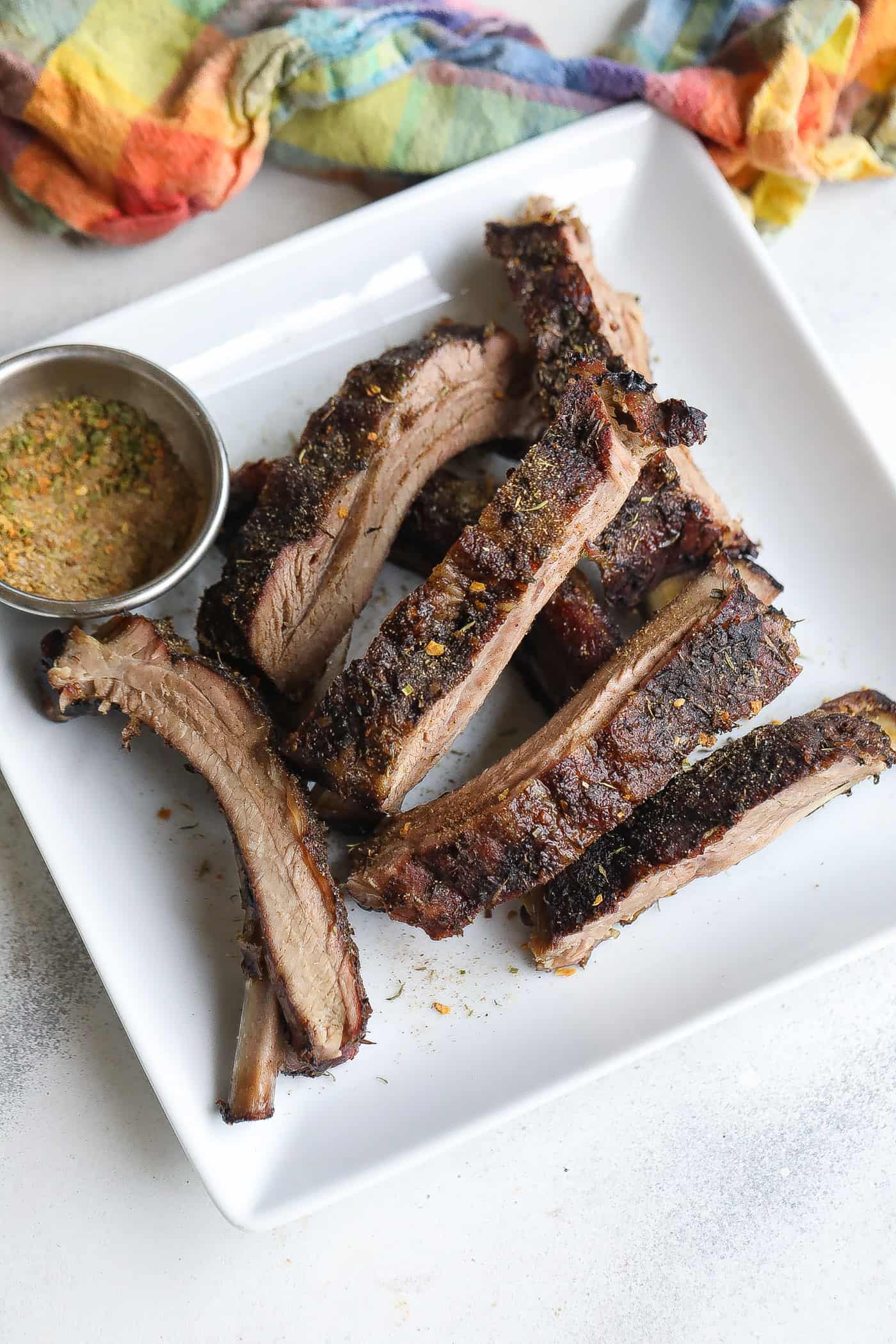 4 ribs on a white plate topped with dry spices