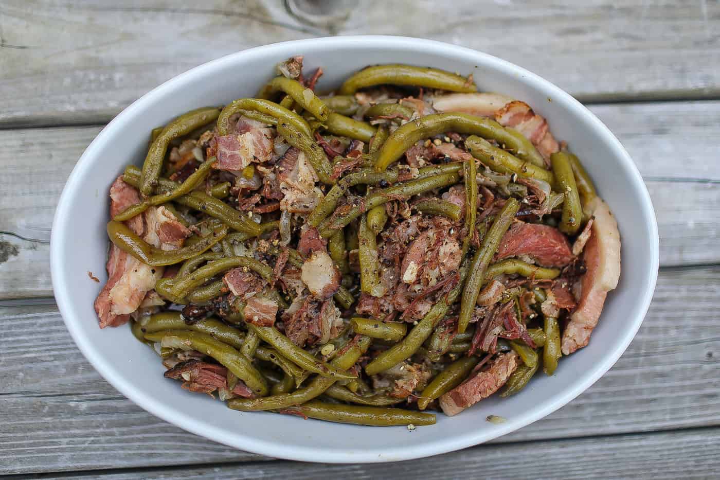 green beans and bacon in white oval bowl