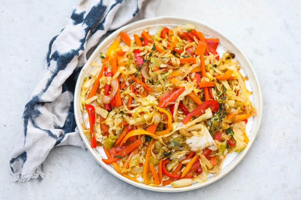 colorful jamaican steamed cabbage in white pan