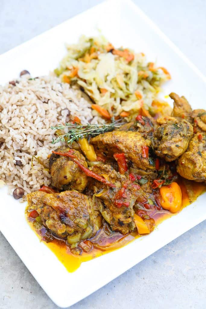 coconut curry chicken with rice and cabbage on white plate