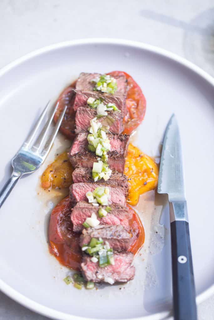 sliced steak topped with vinaigrette