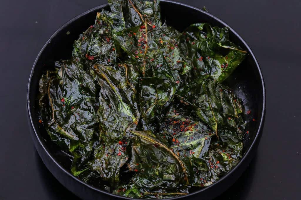 fried collard greens in black bowl