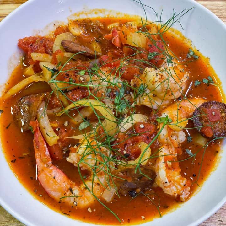 shrimp, fennel, and sausage soup in a white bowl