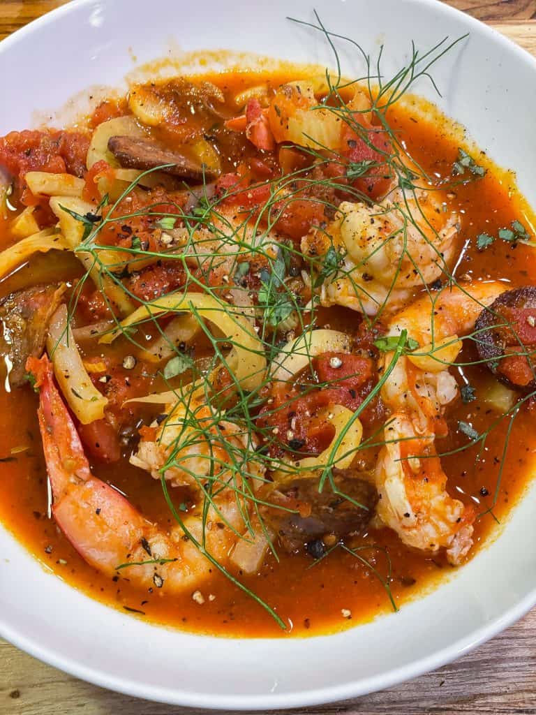 shrimp, fennel, and sausage soup in a white bowl