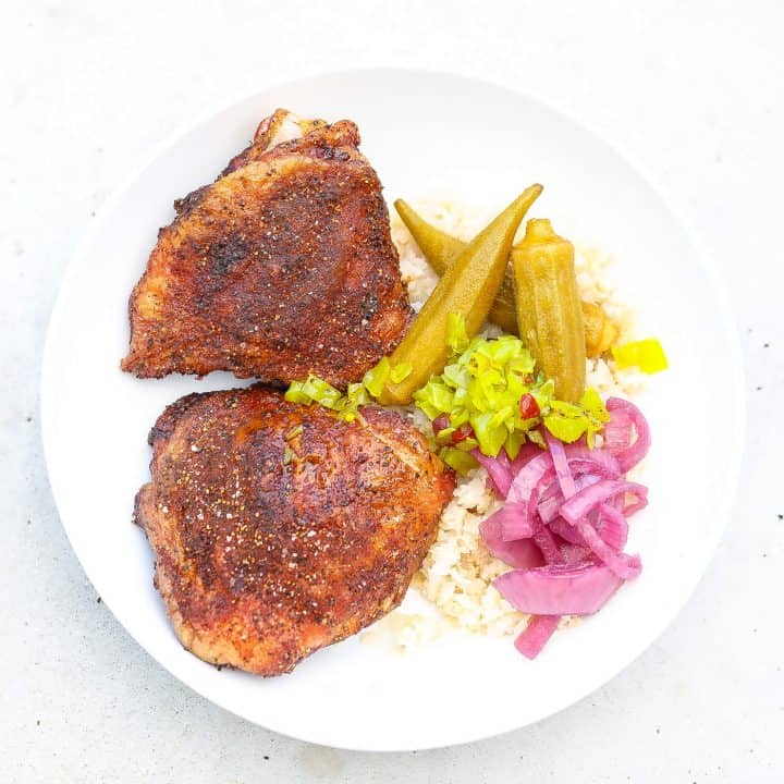 smoked chicken thighs in a white bowl with onions and okra