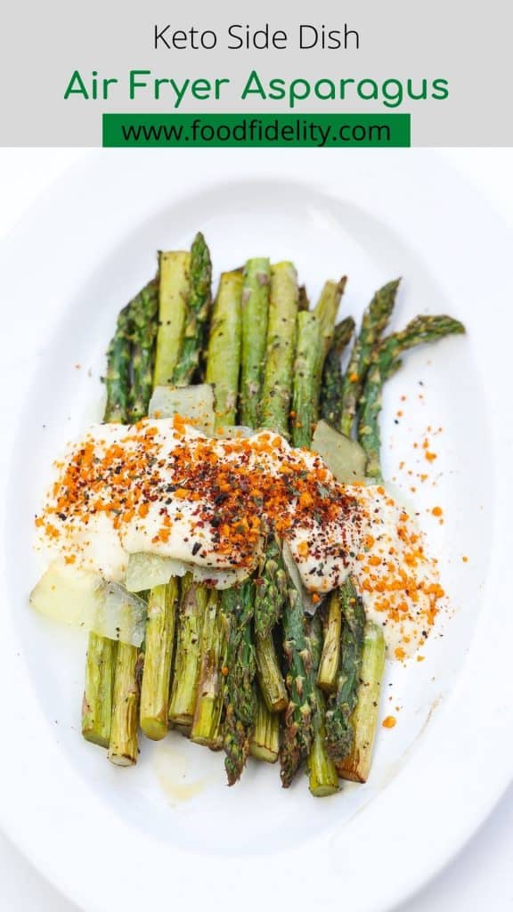 asparagus on a white plate topped with cheese sauce