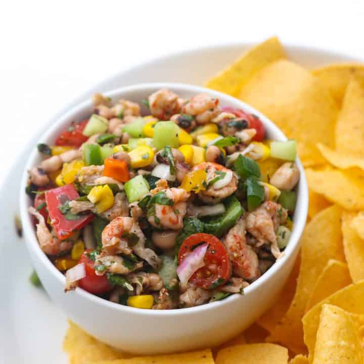 tortilla chips and black eyed salad in a white bowl