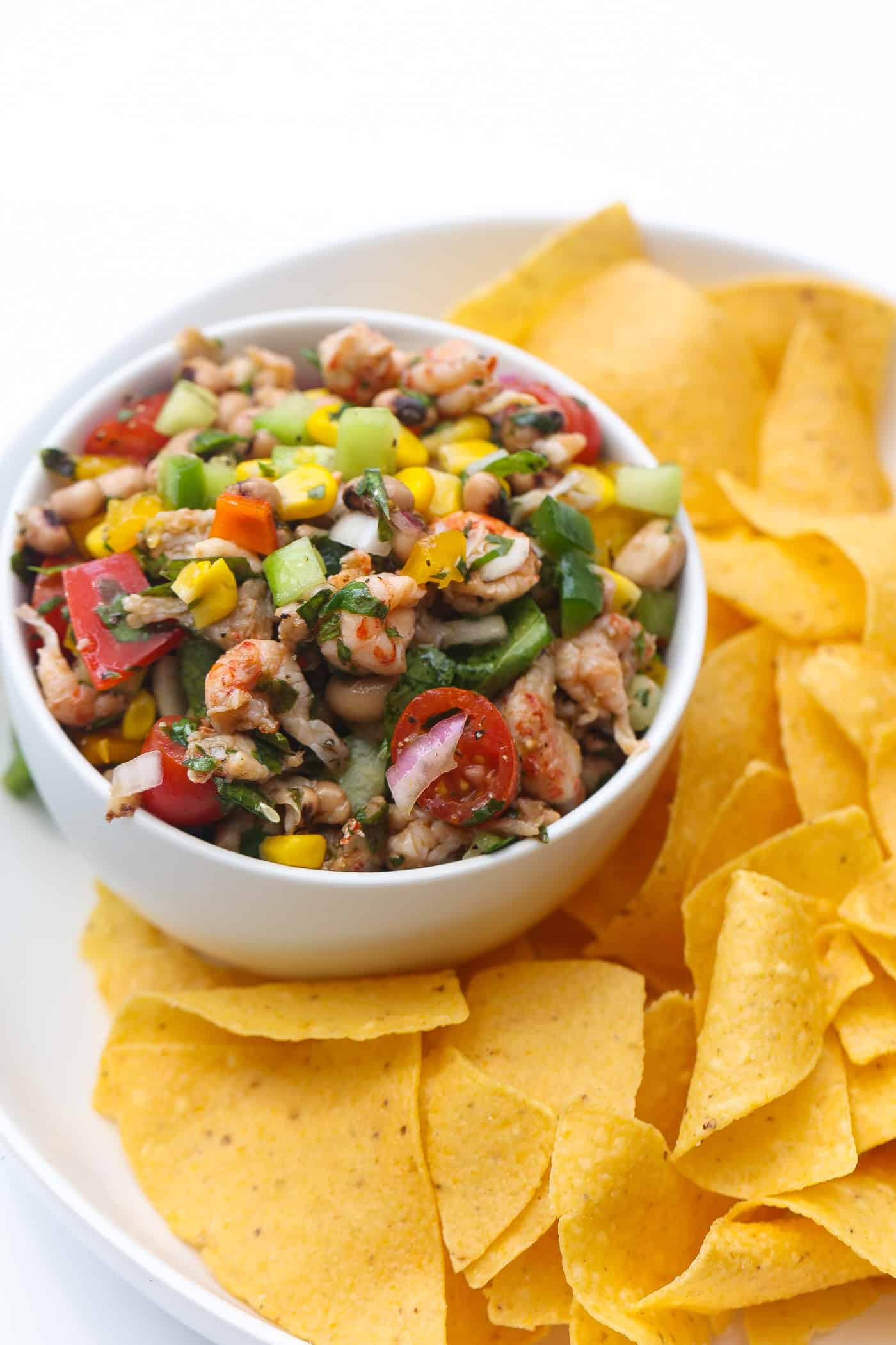 tortilla chips and black eyed salad in a white bowl