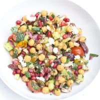 chickpea salad with pomegranate seeds in white bowl