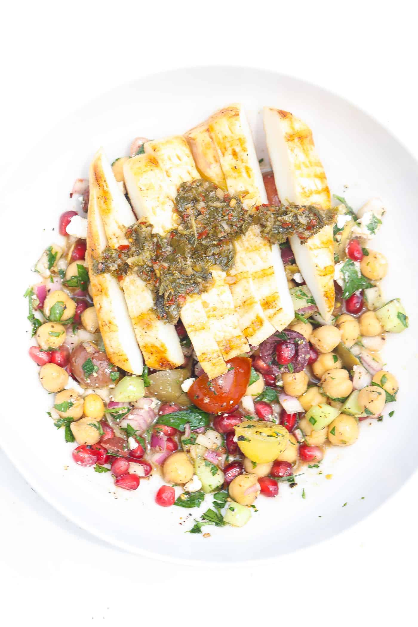 chickpea salad with pomegranate seeds in white bowl