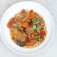 country-style pork ribs with rice topped with sauce and carrots