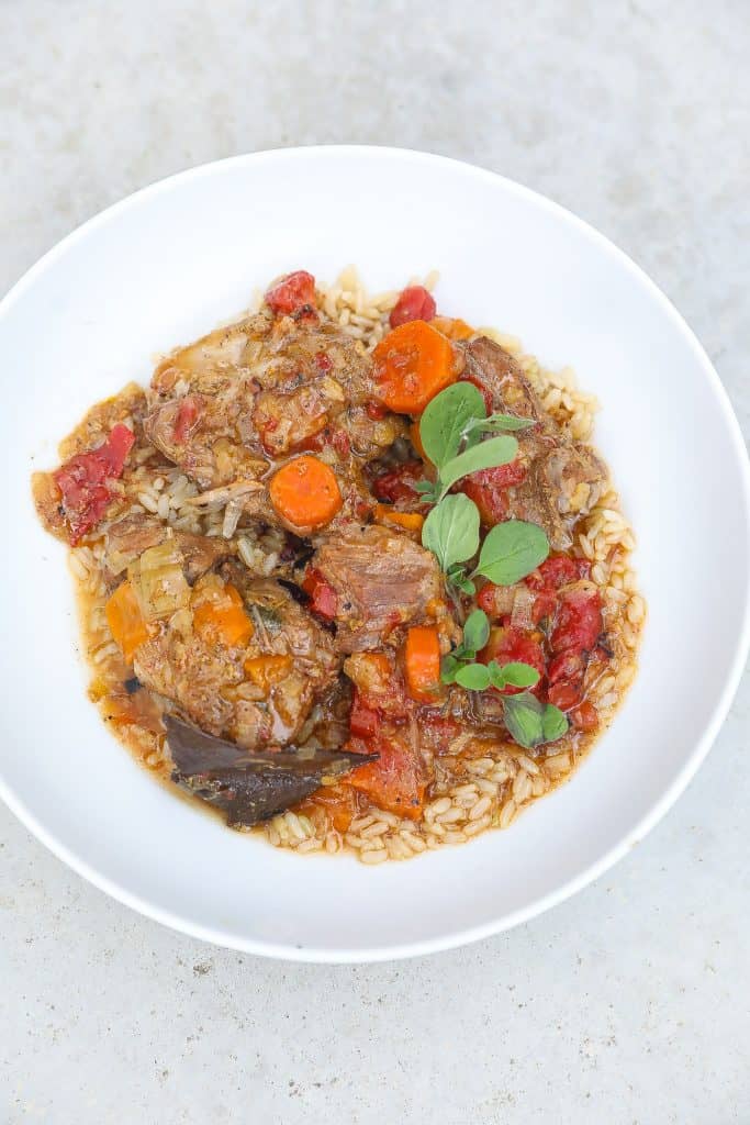 country-style pork ribs with rice topped with sauce and carrots