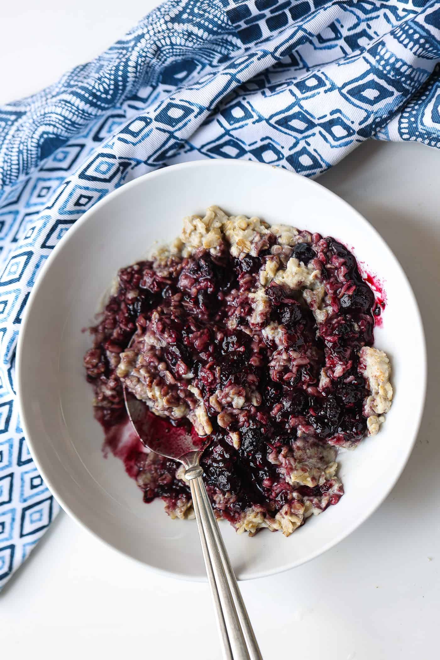 bowl of oatmeal topped with blueberry sauce