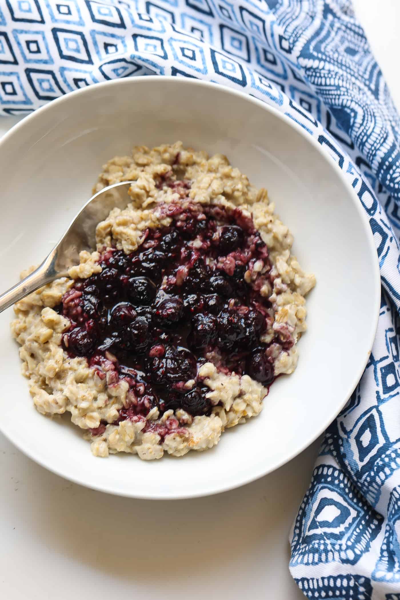 bowl of oatmeal topped with blueberry sauce