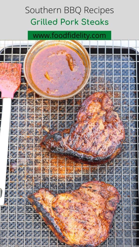 two grilled pork chops with barbecue sauce on wire rack