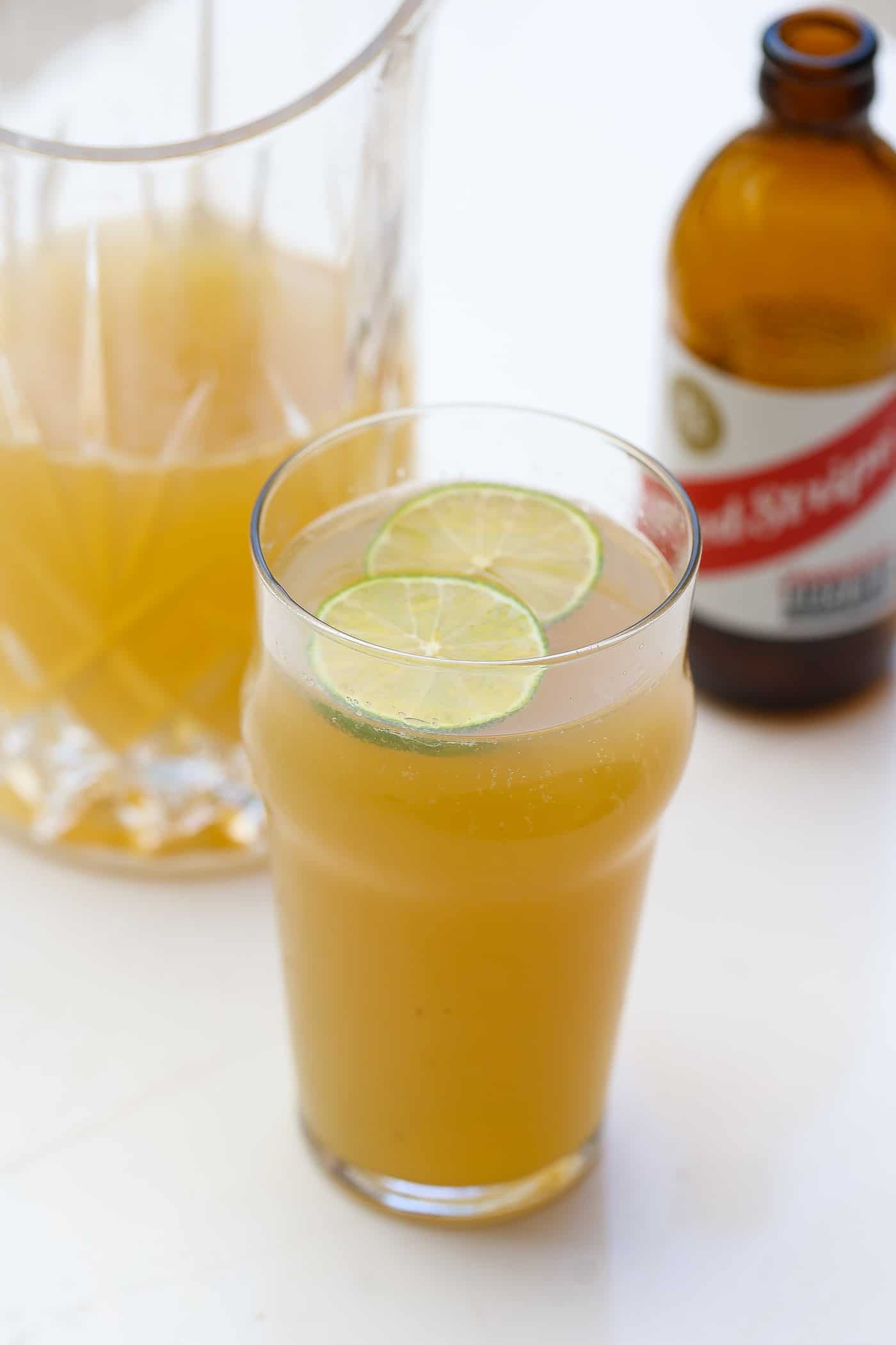 glass of beer flanked by a pitcher and bottle of beer