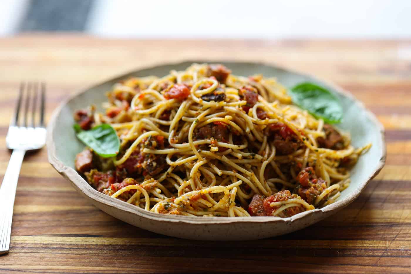 spaghetti and sausage cubes on a plate