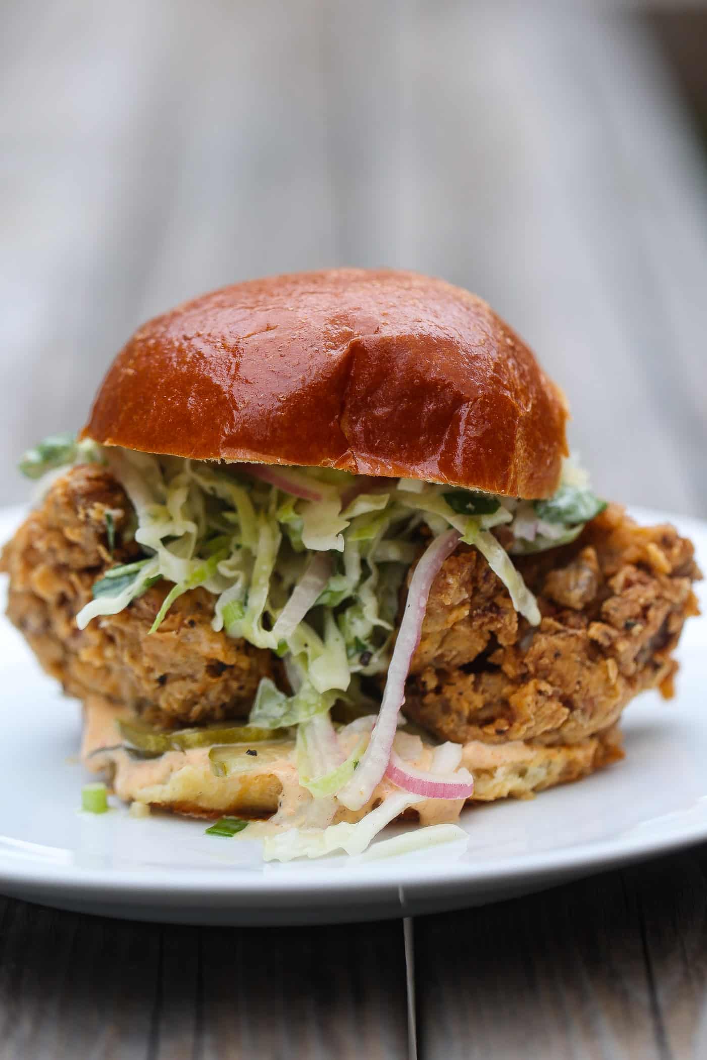 vegan fried chicken sandwich with slaw on a white plate