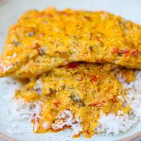 red snapper fish filet with yellow sauce and rice