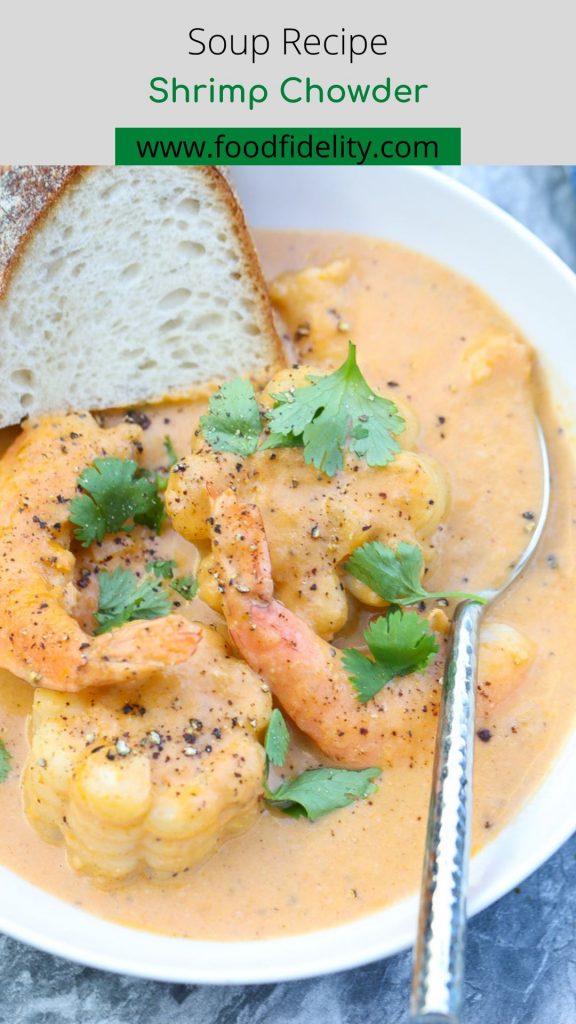 shrimp and corn in a white bowl with bread slice