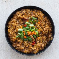 blackeyed peas, rice, green onions, and peppers in black bowl