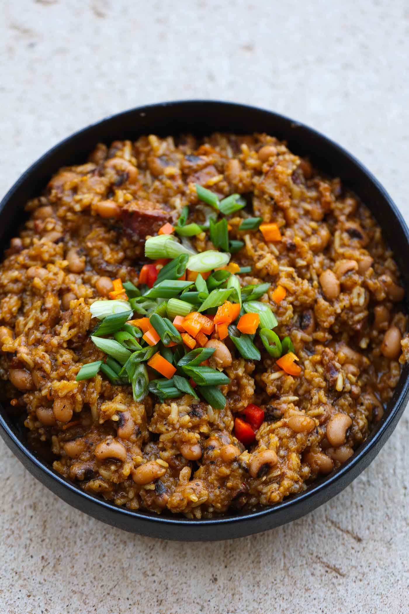 blackeyed peas, rice, green onions, and peppers in black bowl