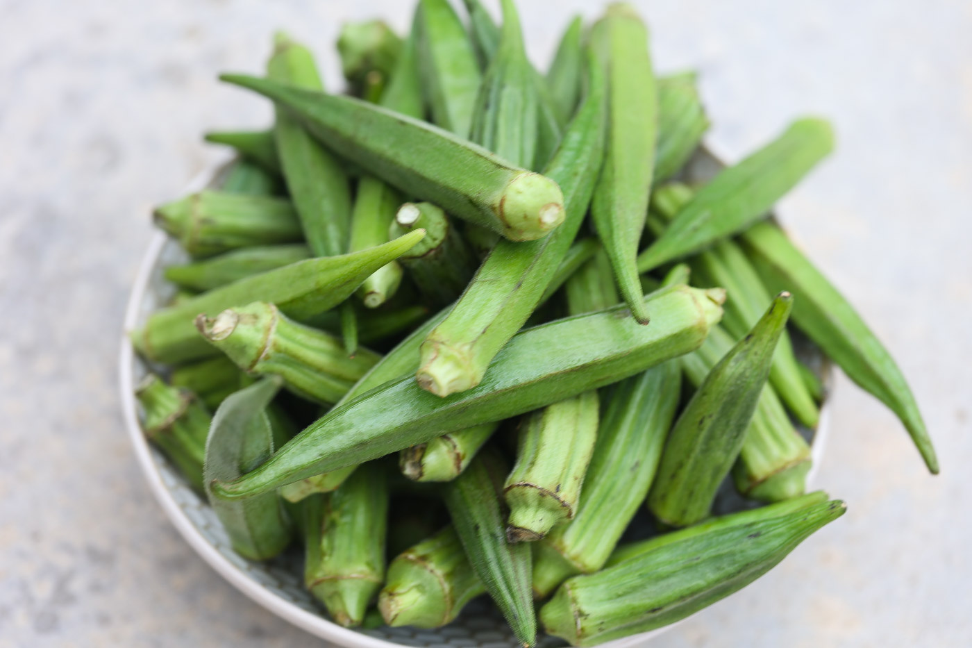 fresh okra in white bowl