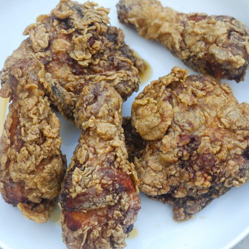 Southern fried chicken pieces on a white plate