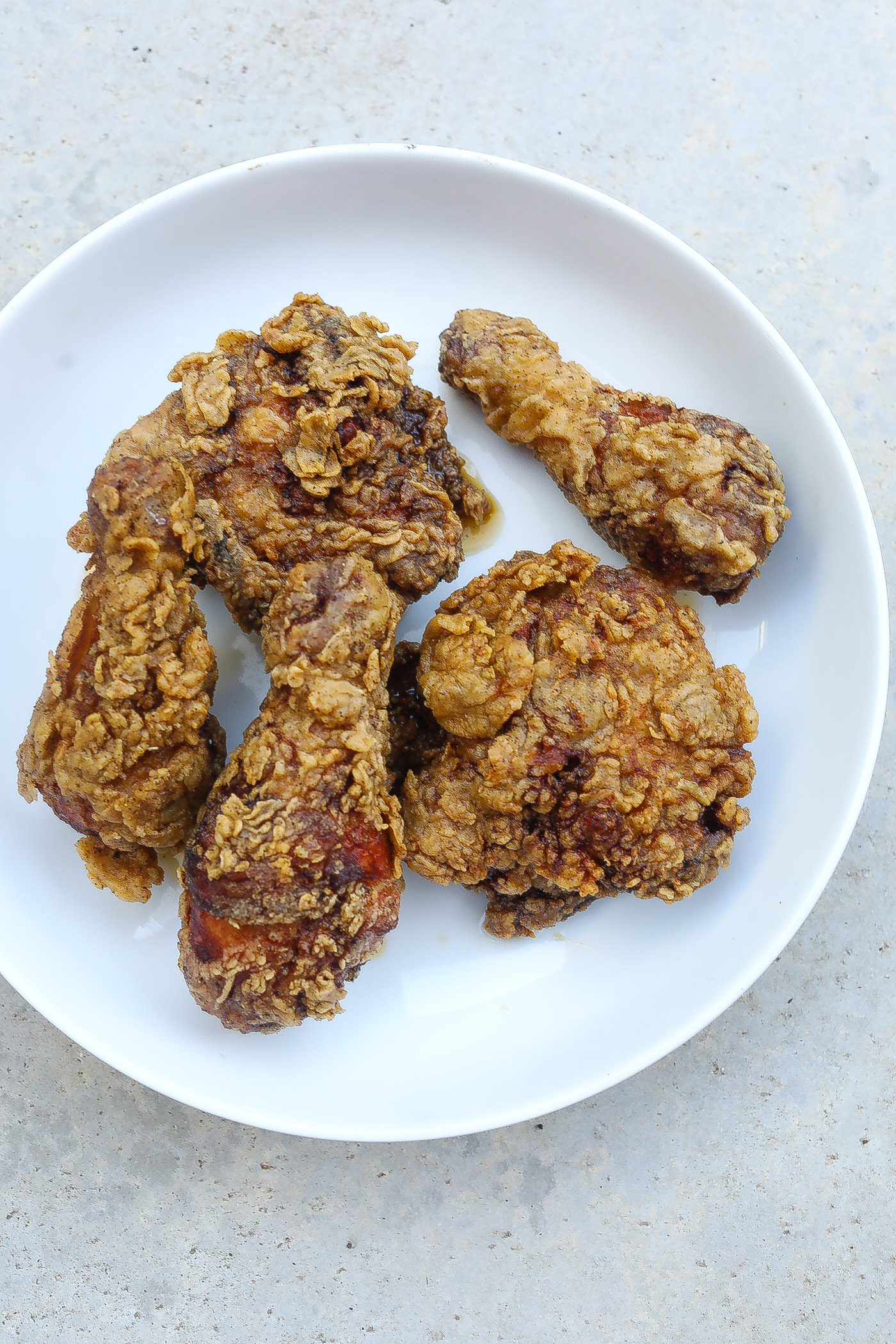 Southern fried chicken pieces on a white plate