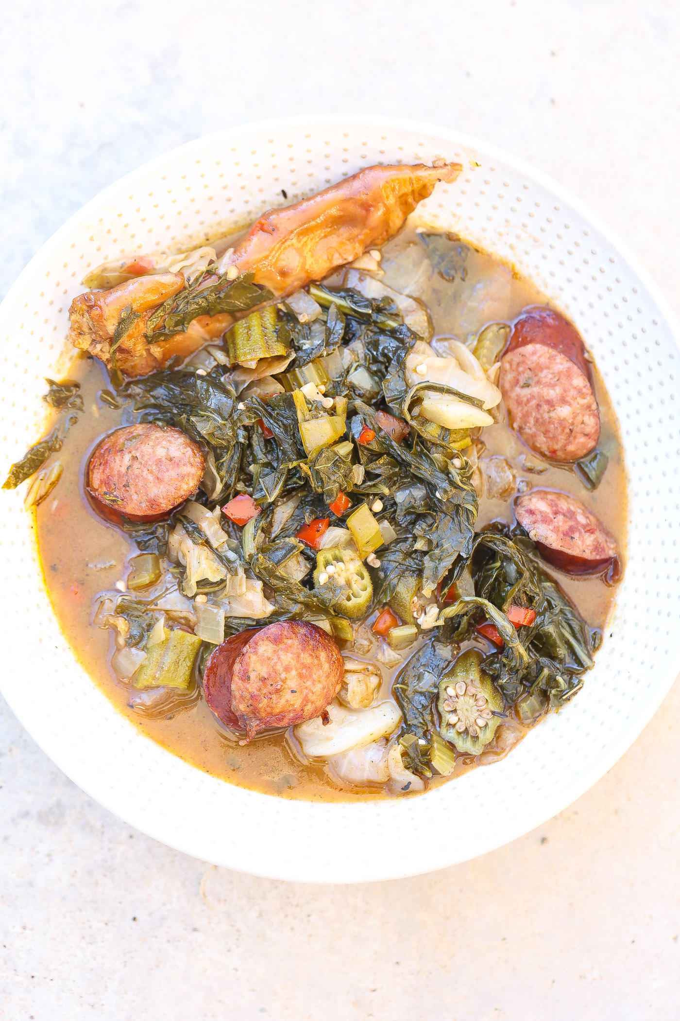 cooked gumbo z'herbes in a white bowl with spoon.
