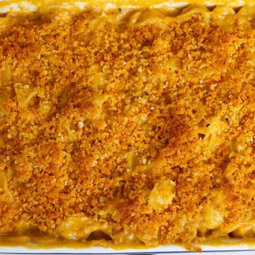 vegan mac and cheese with crunchy topping in a white baking dish
